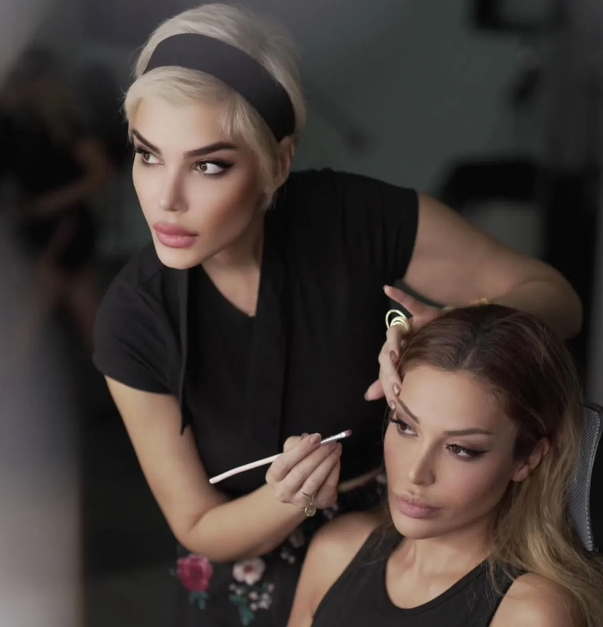 Makeup artist carefully applying eye makeup to a client