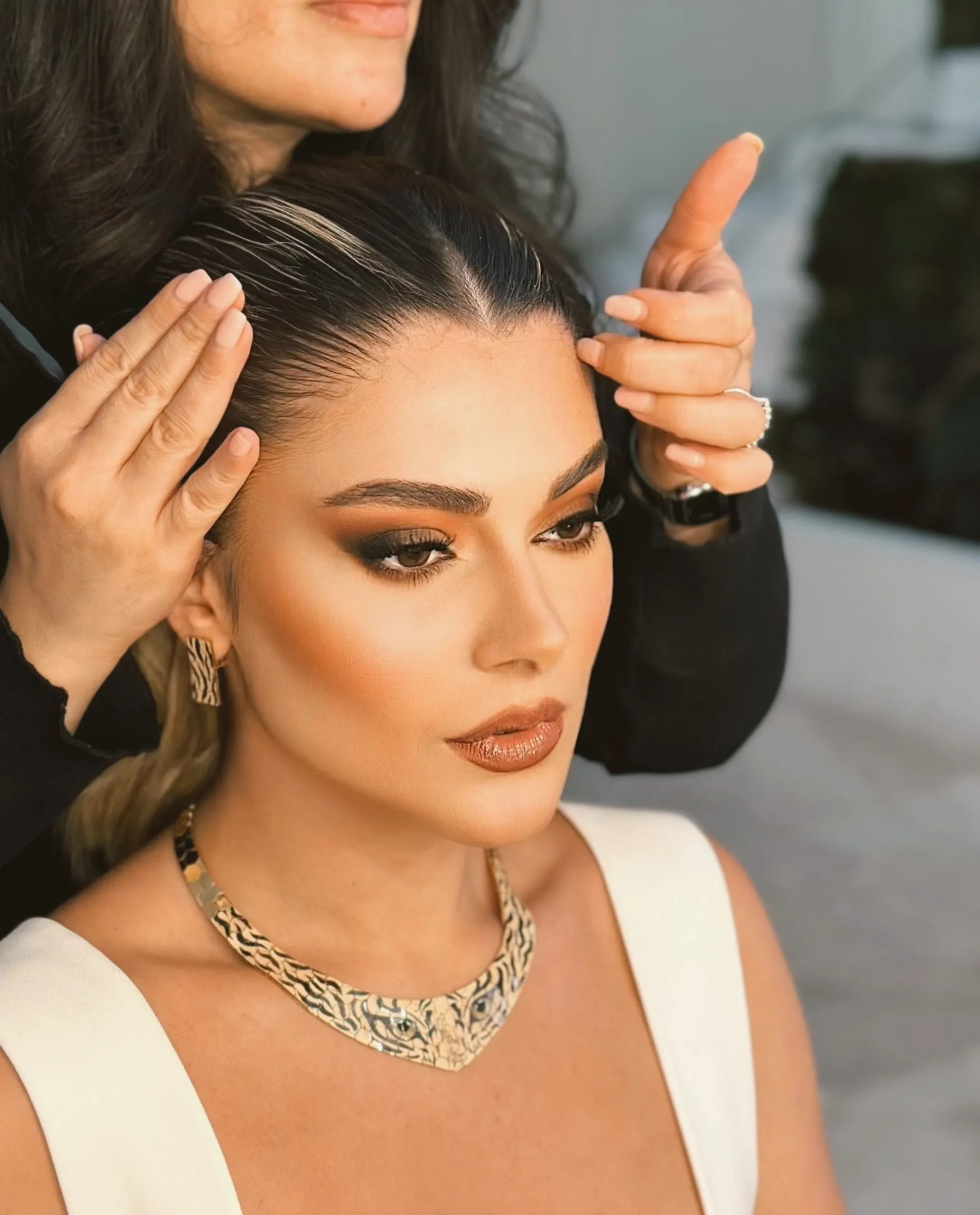 Hairstylist and makeup artist finishing a client’s look