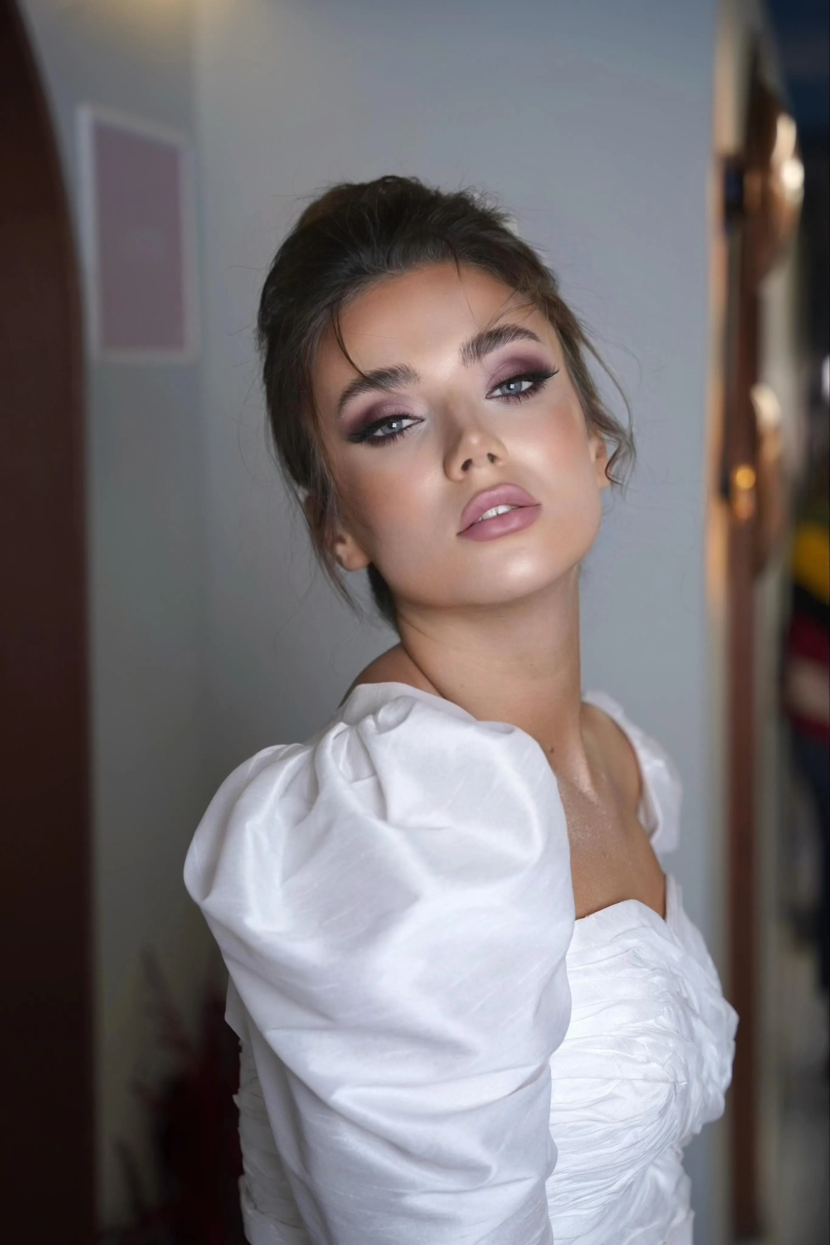 Bride in a white puff-sleeve dress with a soft romantic updo